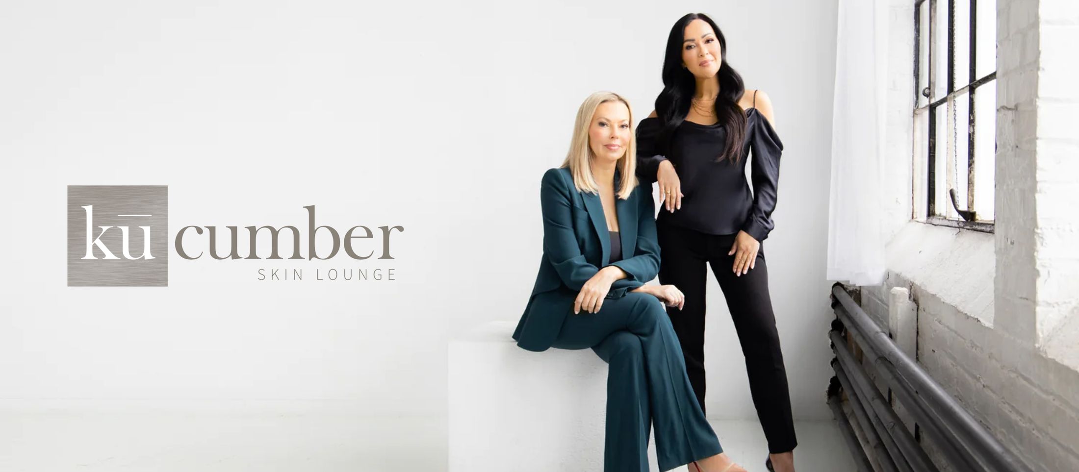 seattle, bellevue, and bellingham med spa owners Nadya Kozlova and Shay Sim by a window