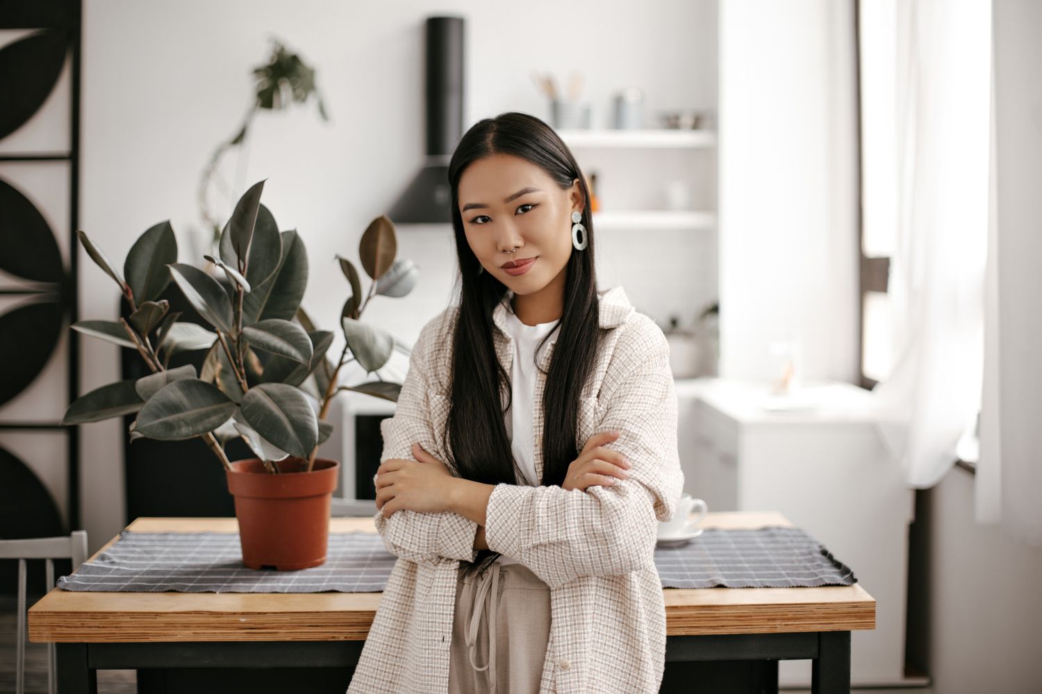 med spa patient model with a cream-colored cardigan leaning against a desk