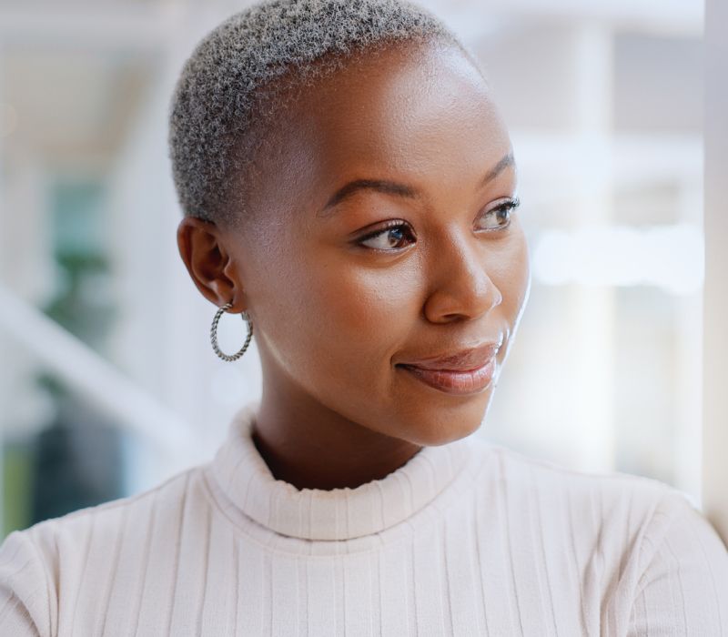ethnic skin treatment patient model wearing a white sweater and hoop earrings