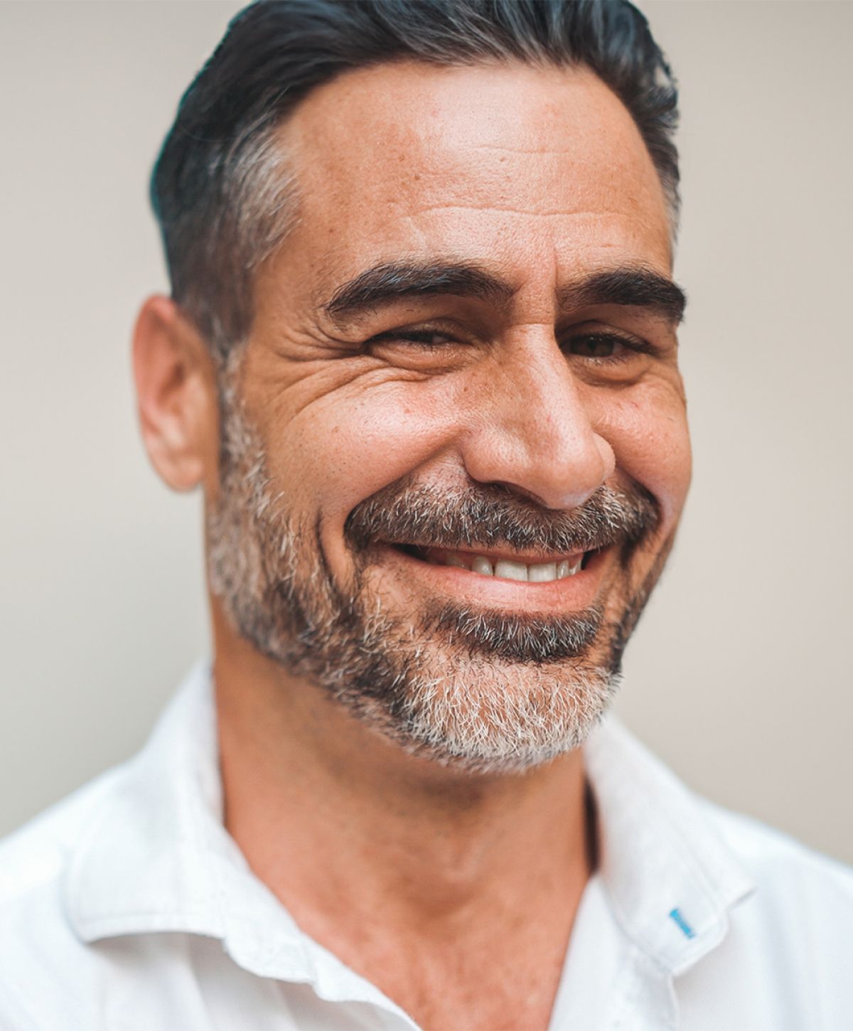 male medspa patient model with a beard smiling