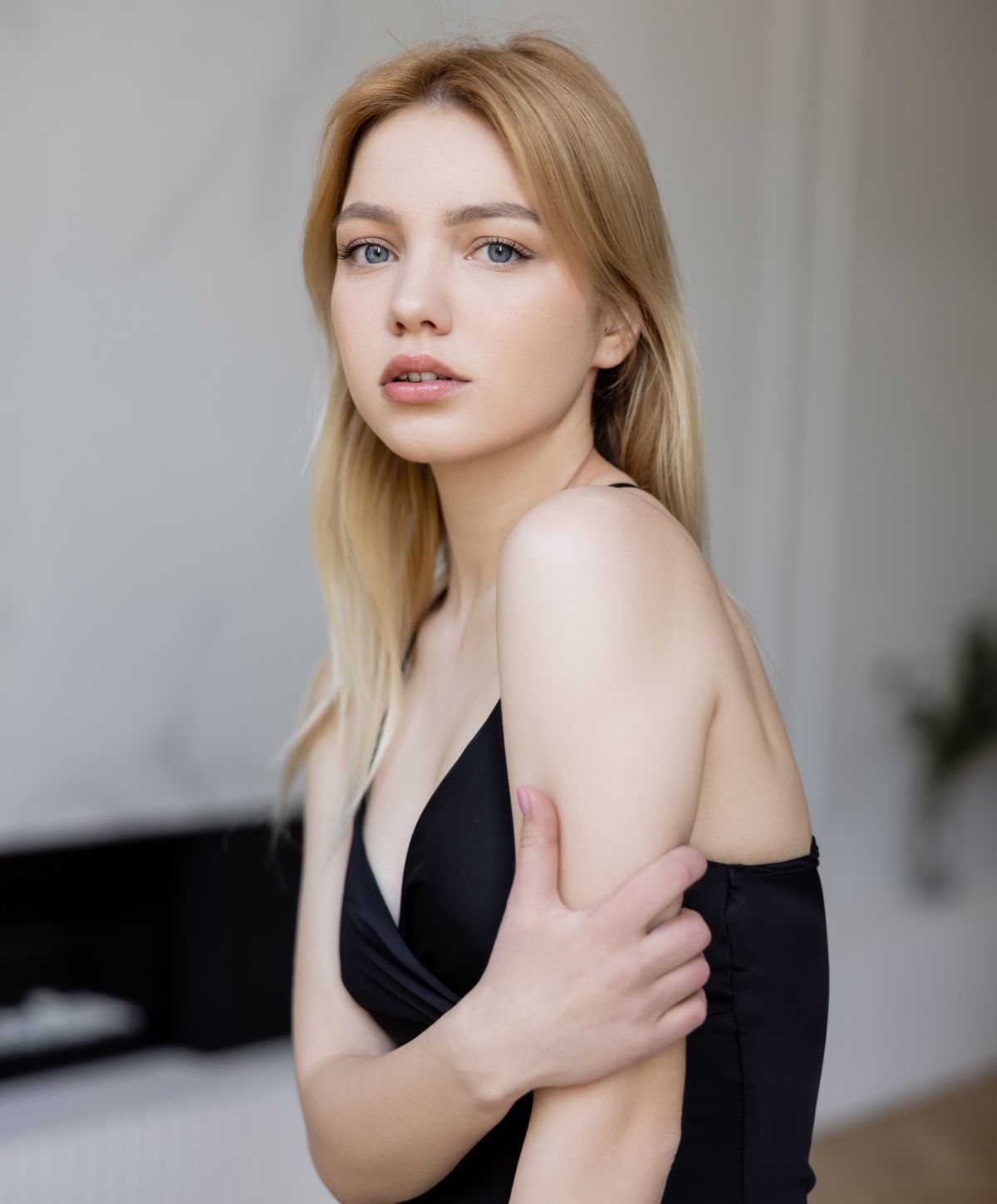 dermal filler patient model in a black dress holding her arm