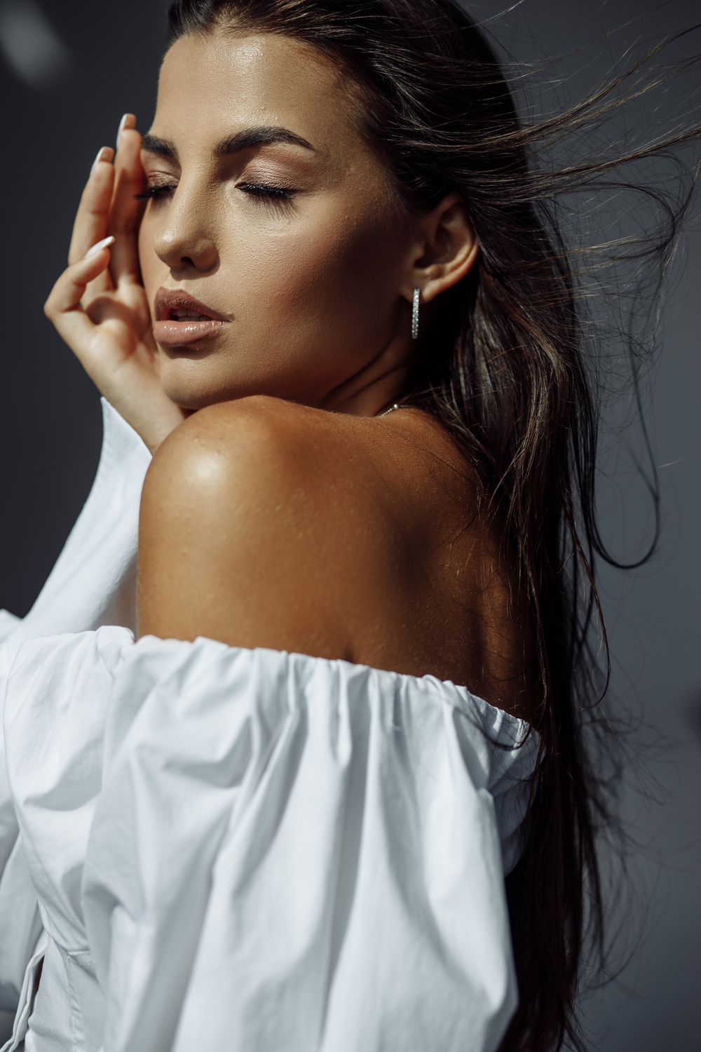 laser tattoo patient model posing with closed eyes and flowing hair.