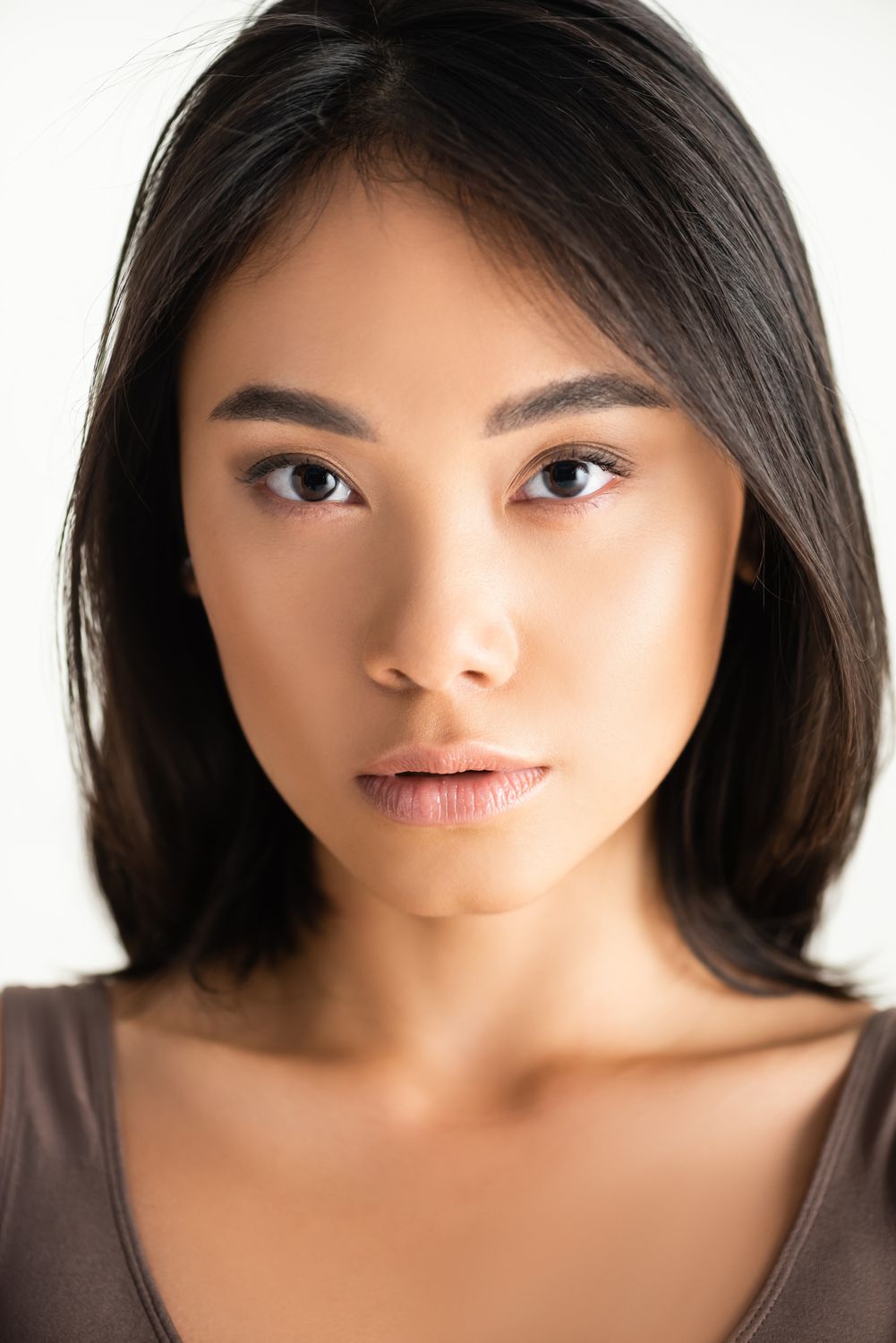 botox patient model with dark hair wearing a brown shirt