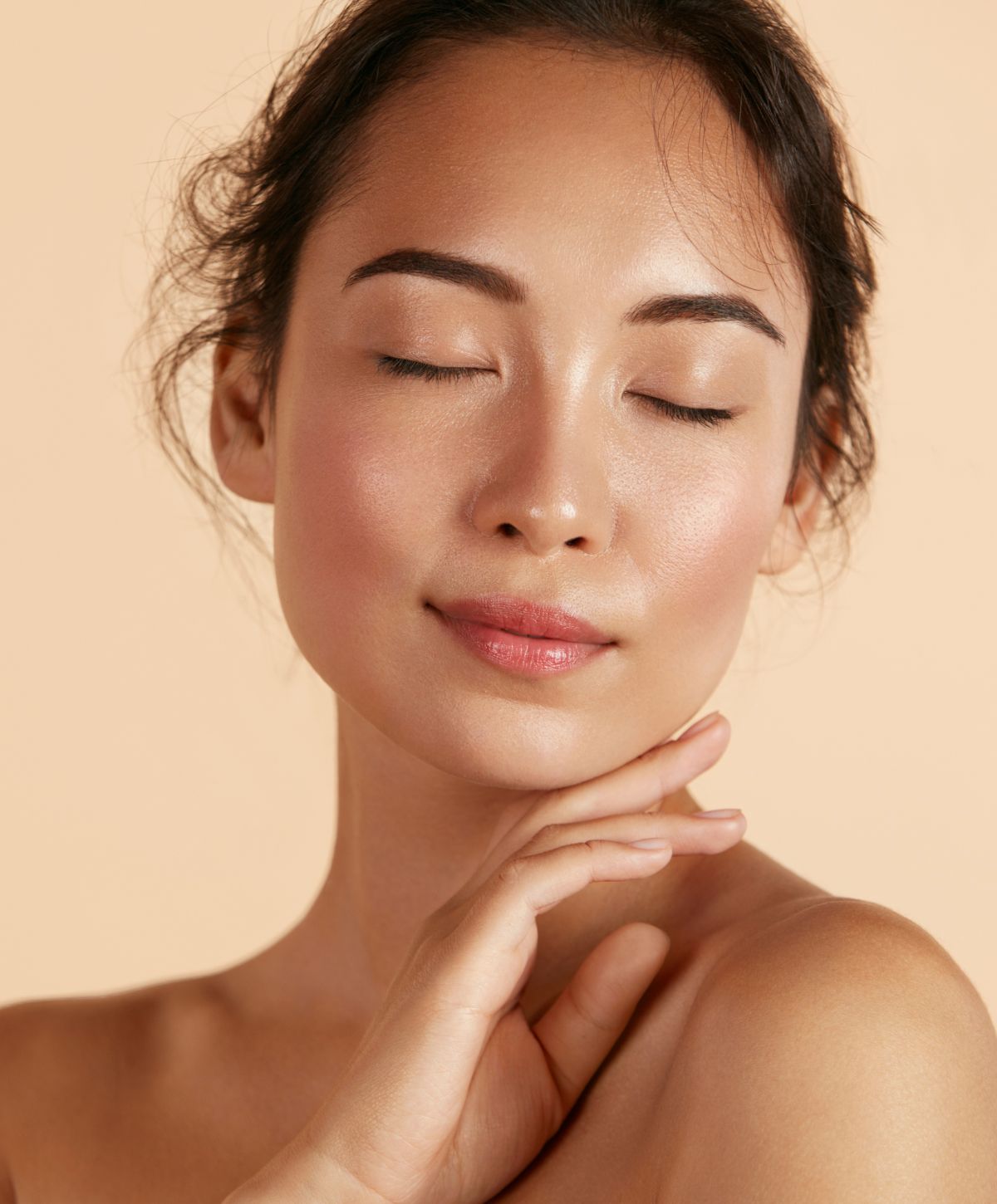 dermaplaning patient model touching her chin with her eyes closed