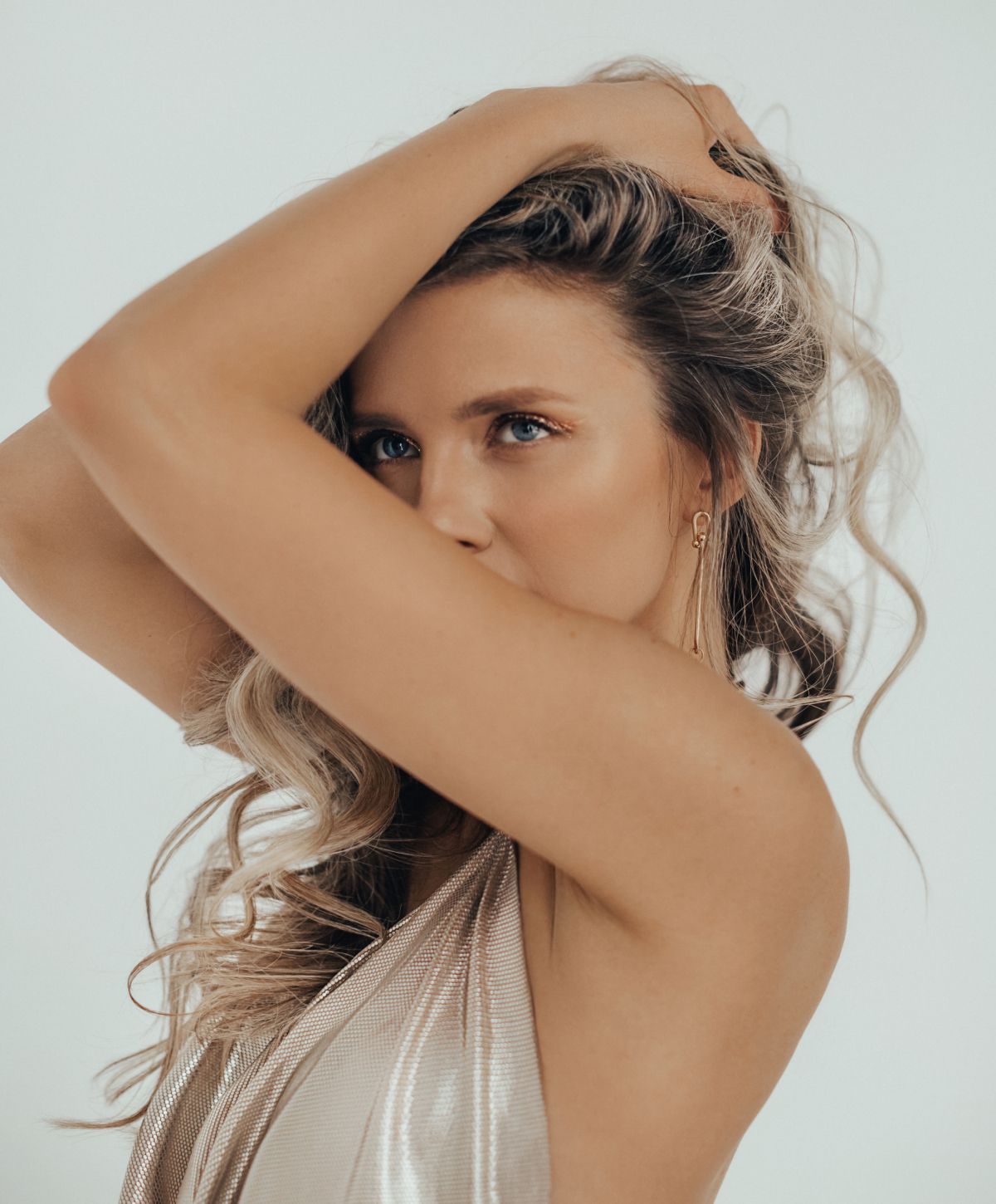 chemical peels patient model in a shimmering dress with her hand on her head