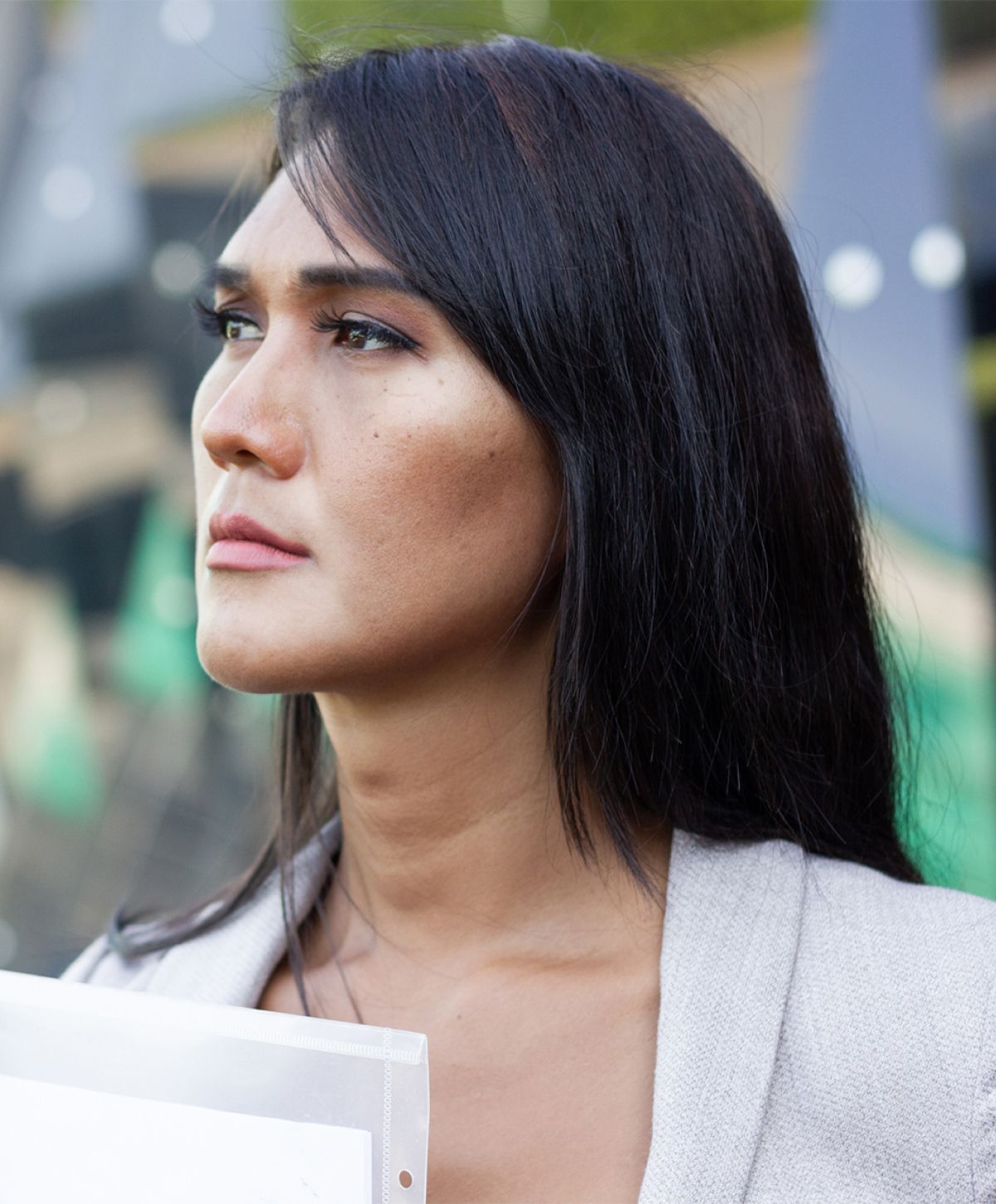 non-surgical feminization treatment patient model in a suit jacket holding a binder