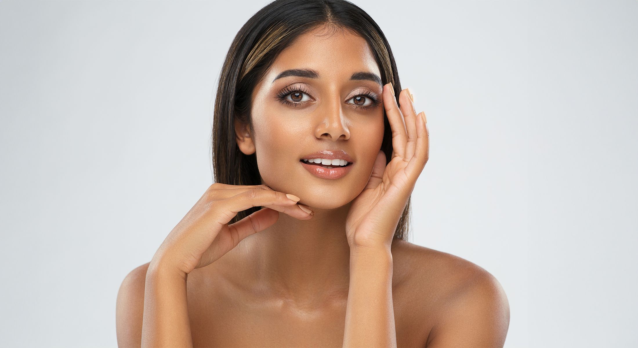 Smiling acne treatment patient model with radiant skin and natural makeup